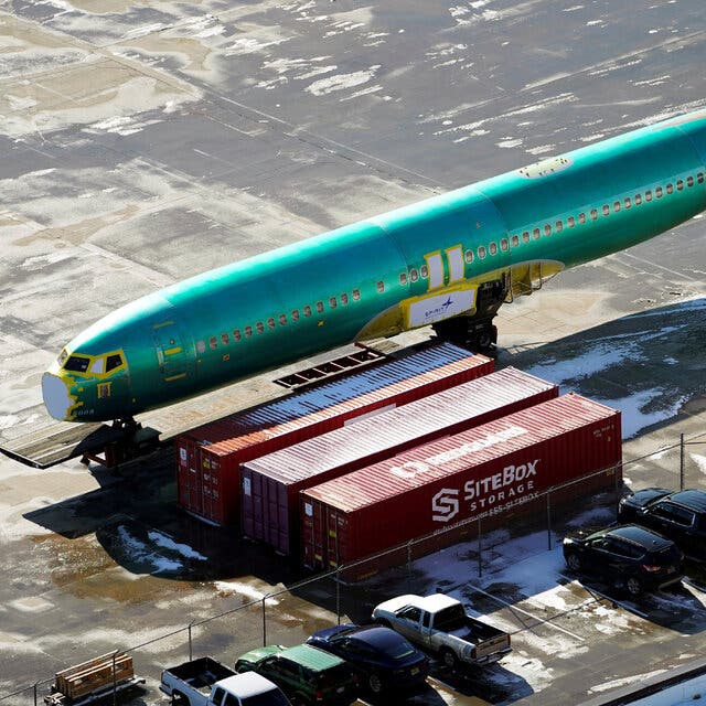 The green body of a 737 Max plane outside a Spirit factory.