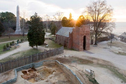 A view of Jamestown, with the church tower, monument and an excavation. Archaeologists found butcher cuts on some of the dog bones they found.