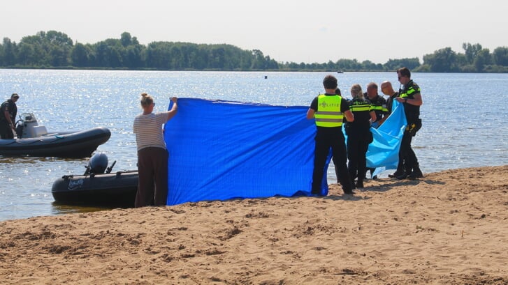 De hulpdiensten schermen het lichaam af als het wordt afgevoerd voor verder onderzoek (foto: AS Media).