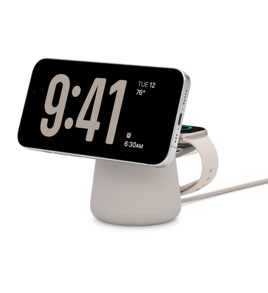 MagSafe-rögzítésű Belkin BOOST CHARGE PRO 2 az 1-ben vezeték nélküli töltődokkoló, fekvő tájolásban töltődő iPhone, mögötte egy Apple Watch töltődik, alatta egy USB-C-s töltőkábel lóg ki