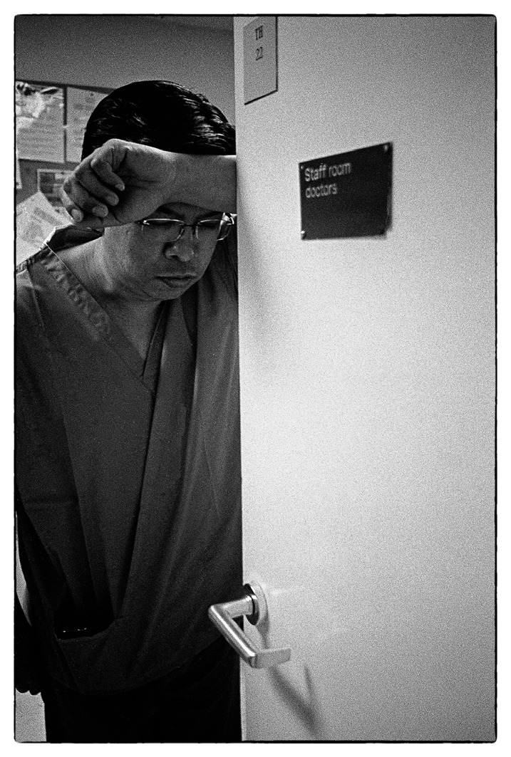 A surgeon gathers his thoughts before donning PPE for another emergency case