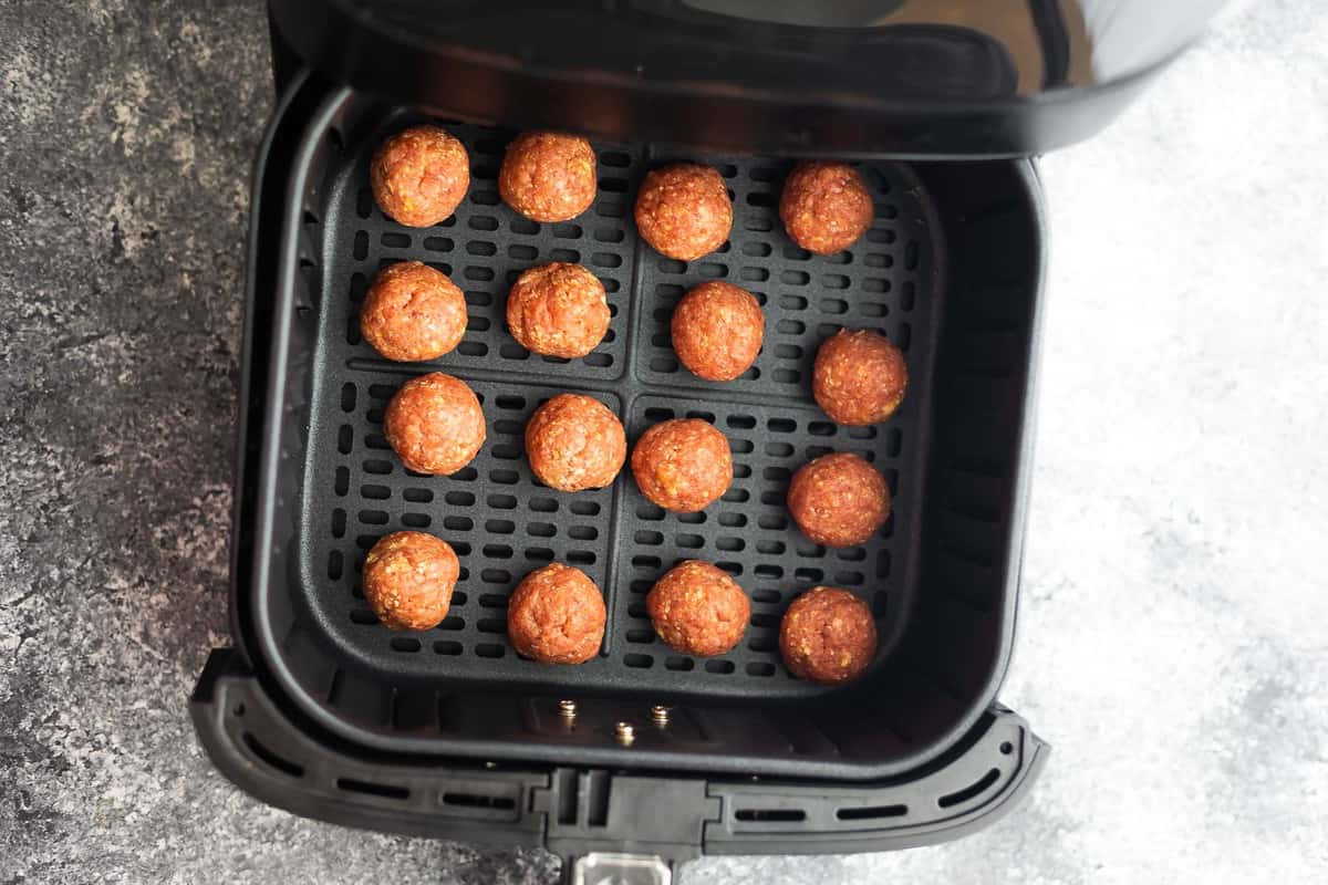 uncooked meatballs in air fryer basket