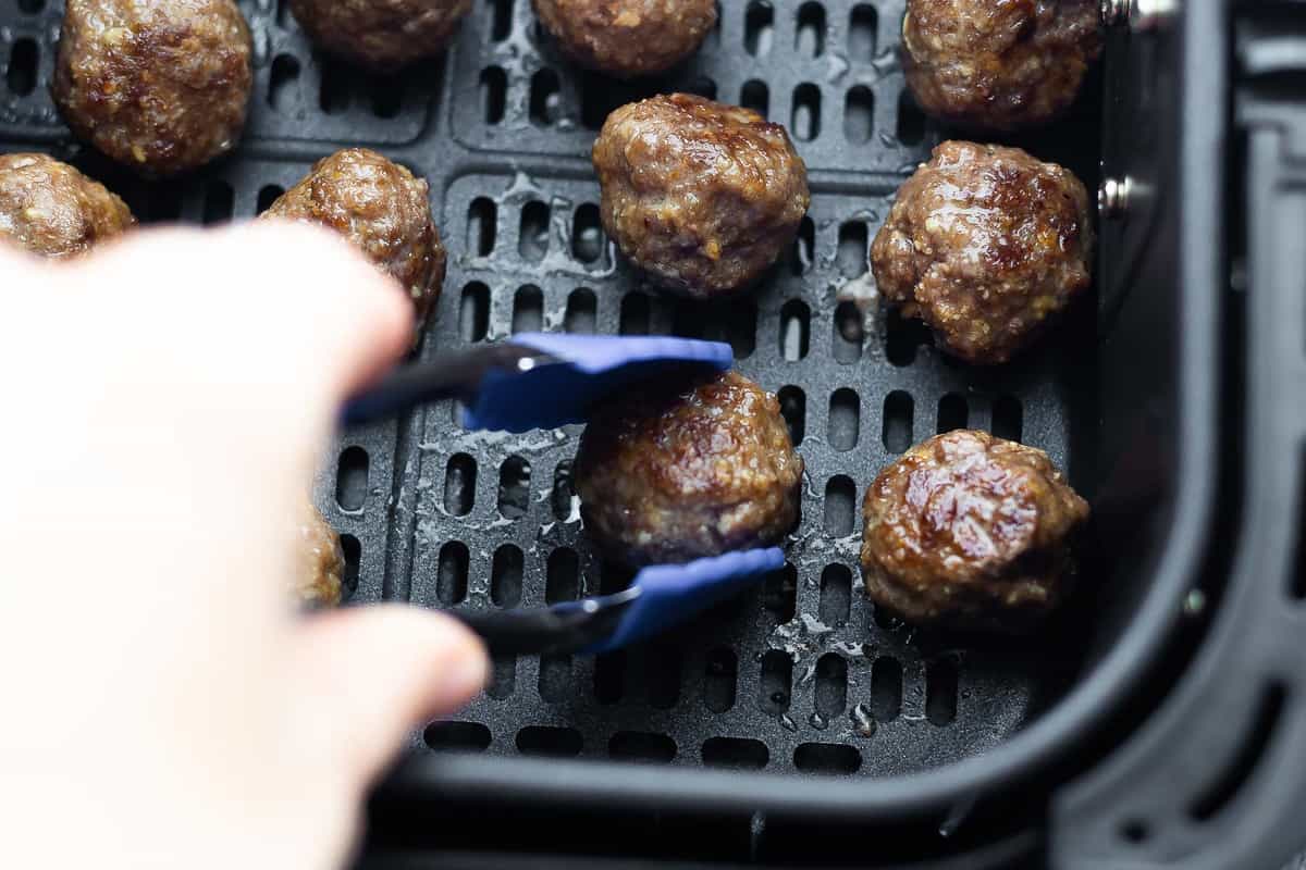 tongs flipping meatballs