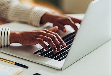 A person typing on their laptop