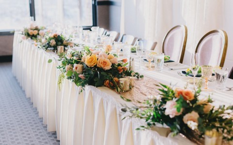 long table with white linens and flower centerpieces