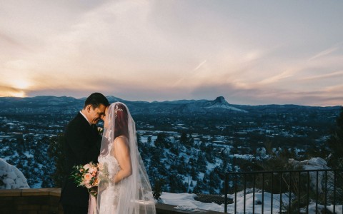 newlyweds kissing on top of mountain