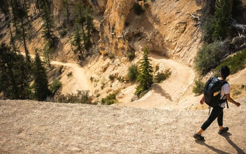 person with a backpack on a hike sunny