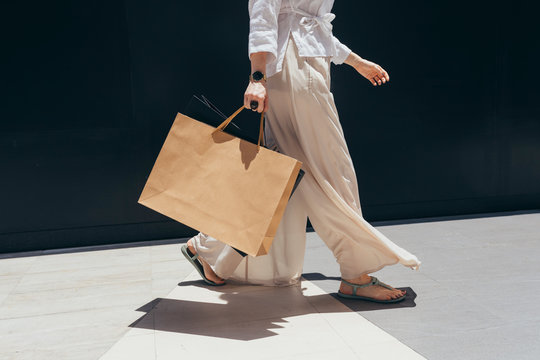 Unrecognisable stylish woman walking with shopping bags.