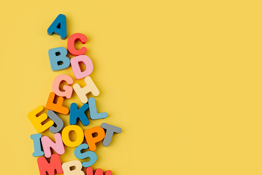 Colorful letters of the alphabet on yellow background. Primary school or preschool, kindergarten. Educational game. Learning through play.