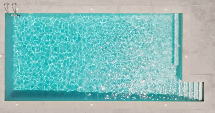 Blue water in the swimming pool with light reflections.