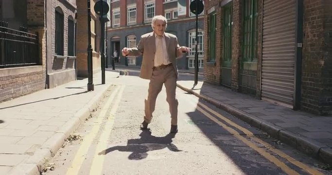 Contemporary funky elderly man street dancer dancing freestyle in the city