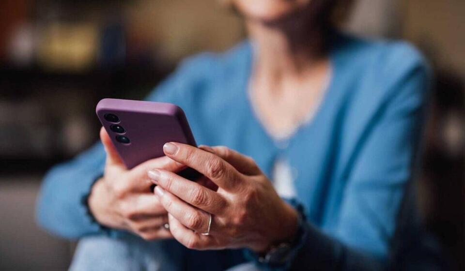 A woman holds a smartphone