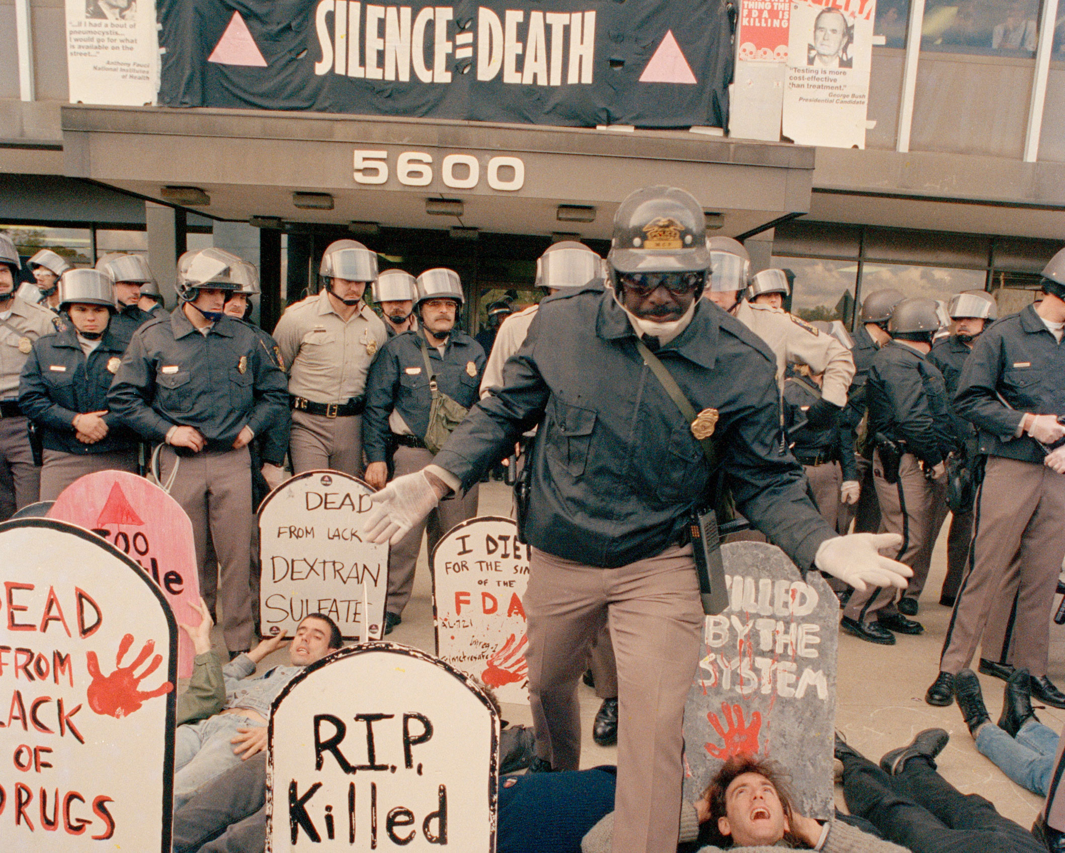 Demonstrators from the organization ACT UP, angry with the federal government's response to the AIDS crisis, protest in front of the headquarters of the Food and Drug Administration in Rockville, Md., Oct. 11, 1988, and effectively shut it down. A police officer steps into the group and by mid-morning some 50 of the protesters were arrested. (AP Photo/J. Scott Applewhite)