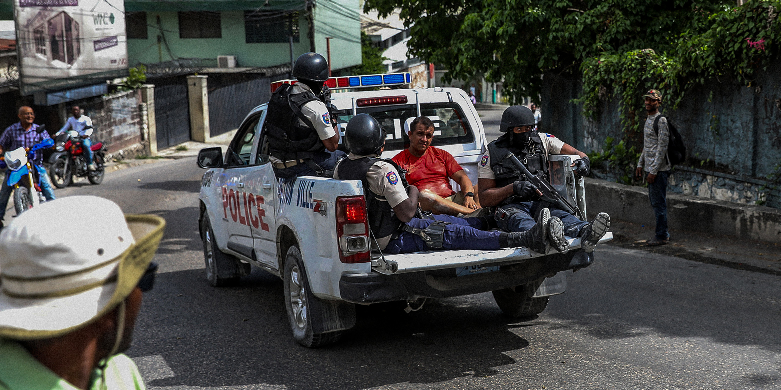 Two men, accused of being involved in the assassination of President Jovenel Moise, are being transported to the Petionville station in a police car in Port au Prince on July 8, 2021. - Police in Haiti have surrounded a group of possible suspects in the assassination of President Jovenel Moise, the UN envoy to Haiti said. Helen La Lime said from the Haitian capital that four members of a group that attacked the presidential palace Wednesday and shot the president have been killed by police and six others are in custody. (Photo by Valerie Baeriswyl / AFP) (Photo by VALERIE BAERISWYL/AFP via Getty Images)