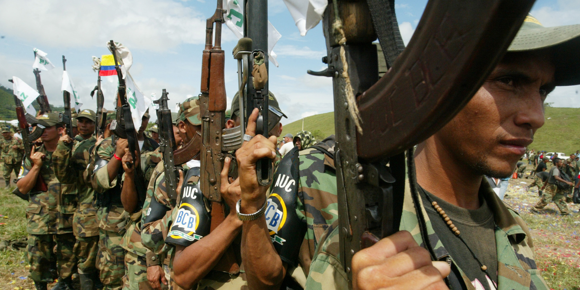Paramilitary fighters hold their rifles during a ceremony to lay down their arms in Otu, northwest Colombia, Monday, Dec.12, 2005. More than 2,000 fighters from the Central Bolivar Bloc of the paramilitary United Self-Defense Forces, or AUC, under the command of Carlos Jimenez alias "Macaco" gathered in this remote hamlet to lay down their arms and two helicopter gunships as part of an ongoing disarmament process.(AP Photo/Fernando Vergara)