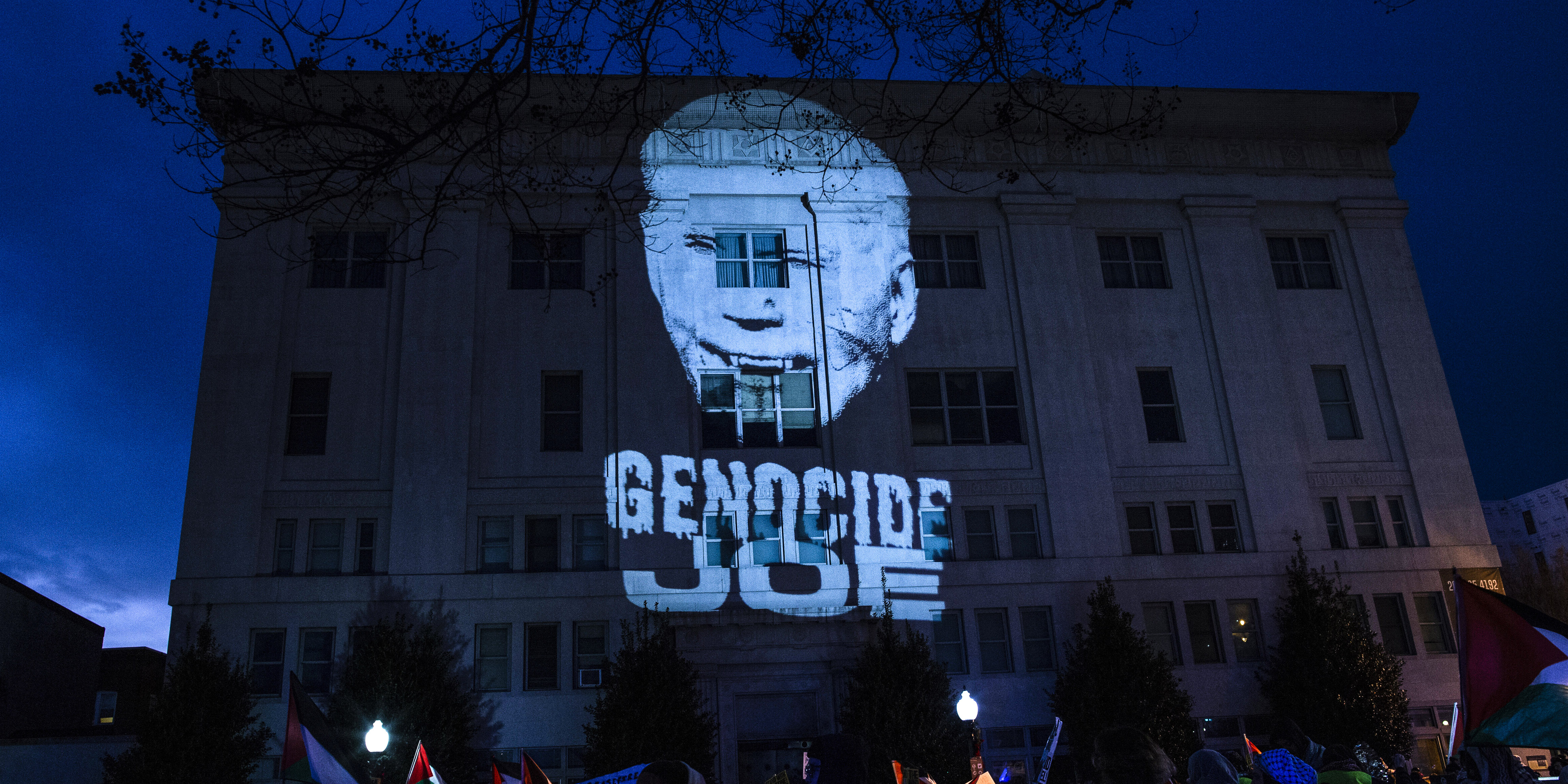 WASHINGTON, DISTRICT OF COLUMBIA, UNITED STATES - 2023/12/31: A projected picture of president Joe Biden with the text reading "Genocide Joe" on the wall of the African American Civil War Memorial Museum during in a Pro-Palestinian demonstation in Washington DC. Pro-Palestinian demonstrators gather at Thomas Circle and then hold a rally with Palestinian flags and banners, calling for a ceasefire in Gaza. (Photo by Probal Rashid/LightRocket via Getty Images)