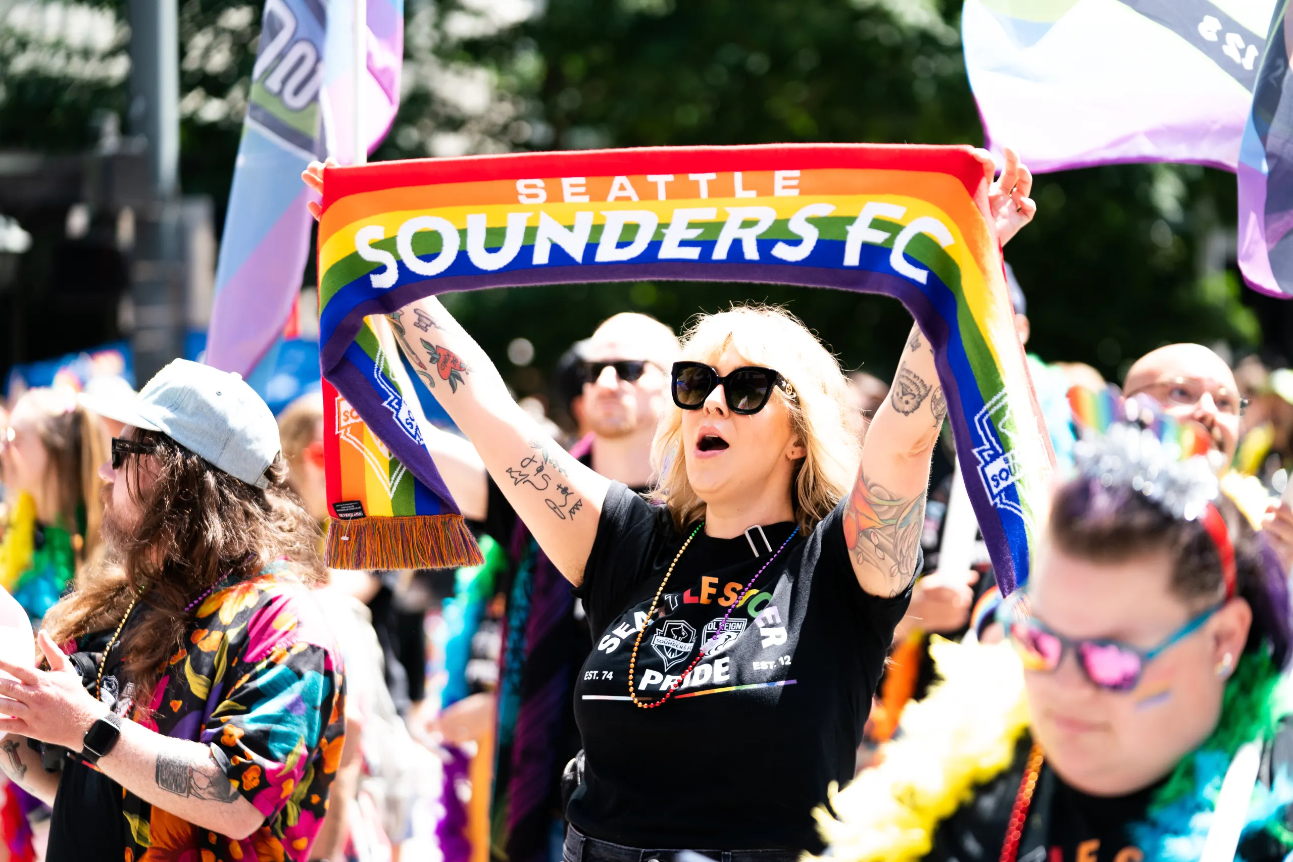 A Sounders fan holds up a rainbow Sounders scarf during a Pride celebration in Seattle.