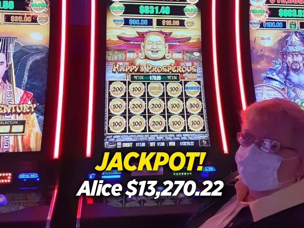 A woman in face mask standing next to a slot machine.