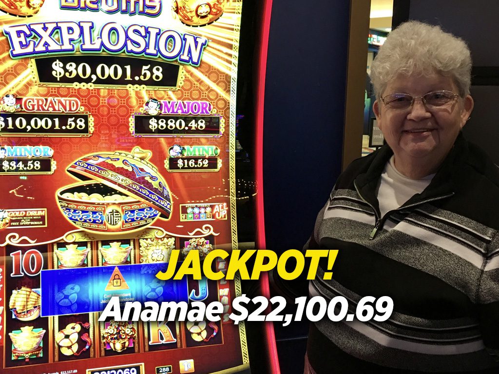 A woman standing next to a slot machine.