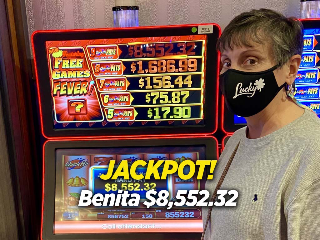 A man standing next to two slot machines.