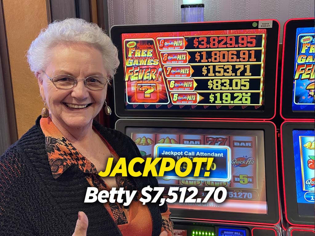 A woman standing next to two slot machines.