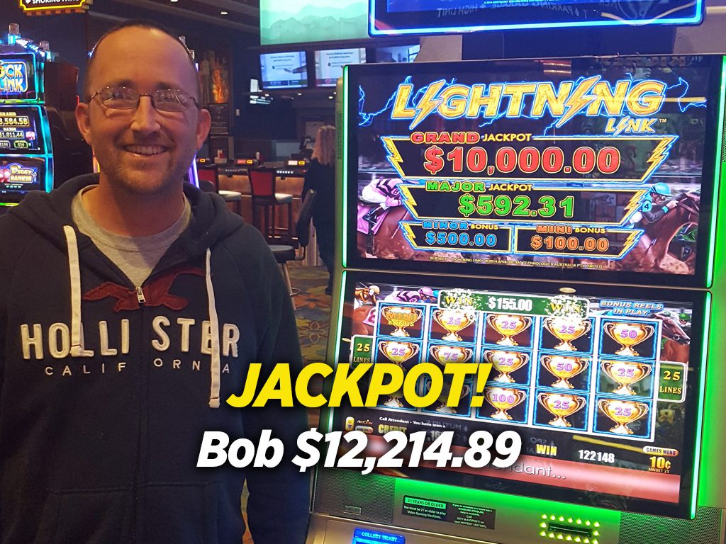 A man standing in front of a slot machine.