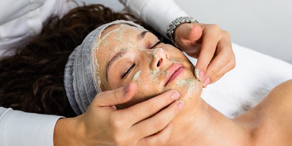 A woman getting her face washed with clay.