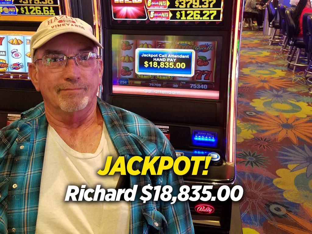 A man sitting in front of a slot machine.