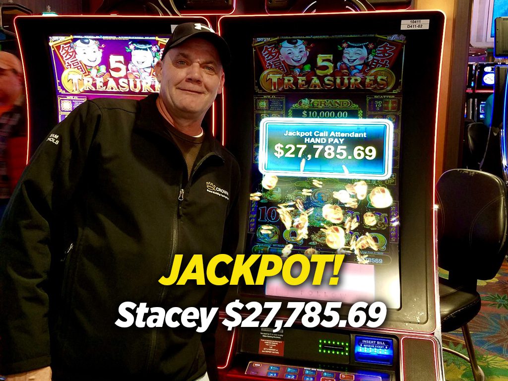 A man standing next to a slot machine.