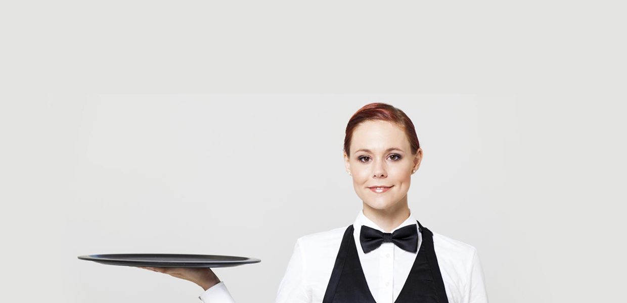 A woman in black and white uniform holding a tray.