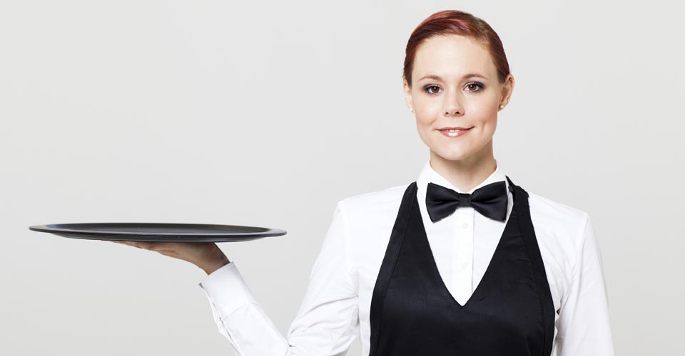 A woman in black and white holding a tray.