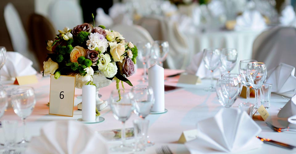 A table set with white plates and glasses