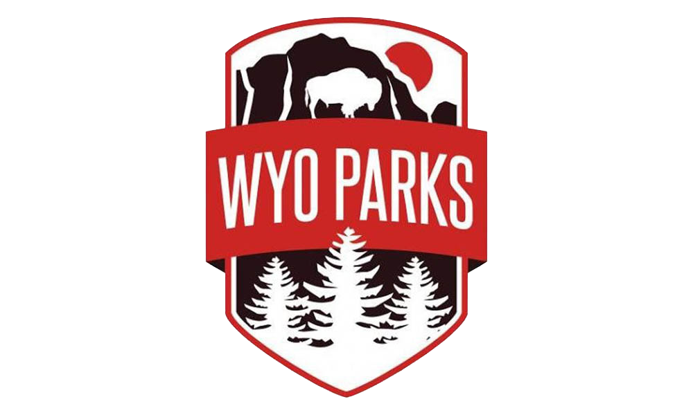 WYO Parks logo. White background with a brown cliff with a white Buffalo and trees in front of the cliff with a red banner with WYO Parks across it.