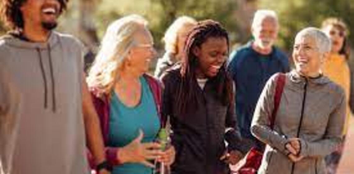 A group of people walking by trees taking a walk together