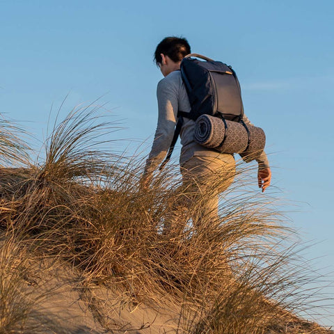 Alvin carrying his everyday backpack with a blanket attached to the external carry straps