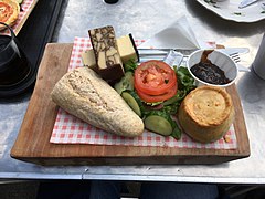 A Ploughman's Lunch. Bread, cheese, salad, butter, a pork pie, and chutney.