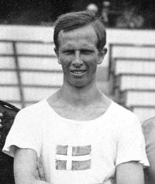 Photographie montrant le haut du corps de Gustaf Dyrssen, portant un t-shirt blanc sur lequel se trouve un drapeau suédois.