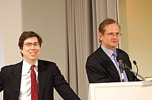 Zittrain smiling and Lessig speaking, both in suits