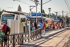 A MAX train stopped at the crowded platform of Milwaukie/Main Street station