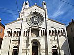 A white stone church with one tall tower.