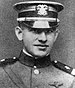 Head of a young man in military uniform with shoulder straps, a high, stiff, collar, and a cap.