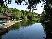 Photograph of buildings with a concrete apron beside a river