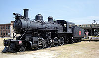 CG locomotive no. 223 in front of the roundhouse. The locomotive is a Baldwin C-3 class 2-8-0, built 1907, ended service 1952.