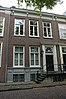 Pand voorzien van gevel met kroonlijst op gesneden consoles, deuromlijsting met pilasters