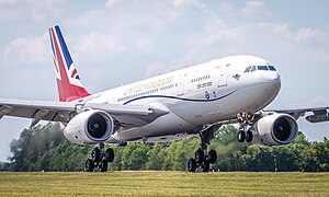 A gloss-white painted aircraft with a red, white and blue 'Union Jack' flag on its vertical tail fin and "United Kingdom" in gold lettering on its upper fuselage landing