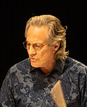 A photograph of a man playing a drum set