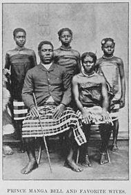 Postcard photo of Prince Manga Bell seated for portrait with four women nearby, possibly late-19th century style