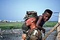 A U.S. Marine carrying a Haitian boy in 1992.