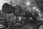 Chaîne de montage du V2 dans le complexe Mittelwerk de Dora. Photo réalisée par l'armée américaine après la prise du complexe fin avril 1945. On distingue un policier militaire américain (MP) devant la fusée.