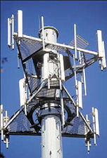 Sector antennas (white bars) on cell phone tower. Collinear arrays of dipoles, these radiate a flat, fan-shaped beam.